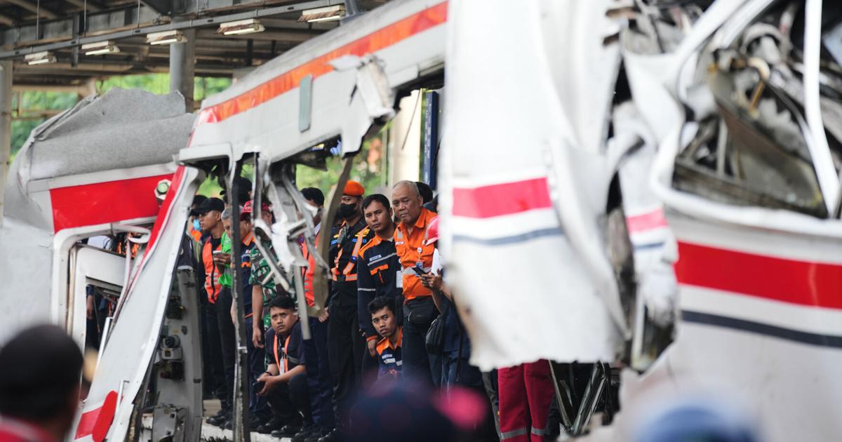 Penyelamat mengeluarkan korban dari kecelakaan kereta di Indonesia, dalam foto