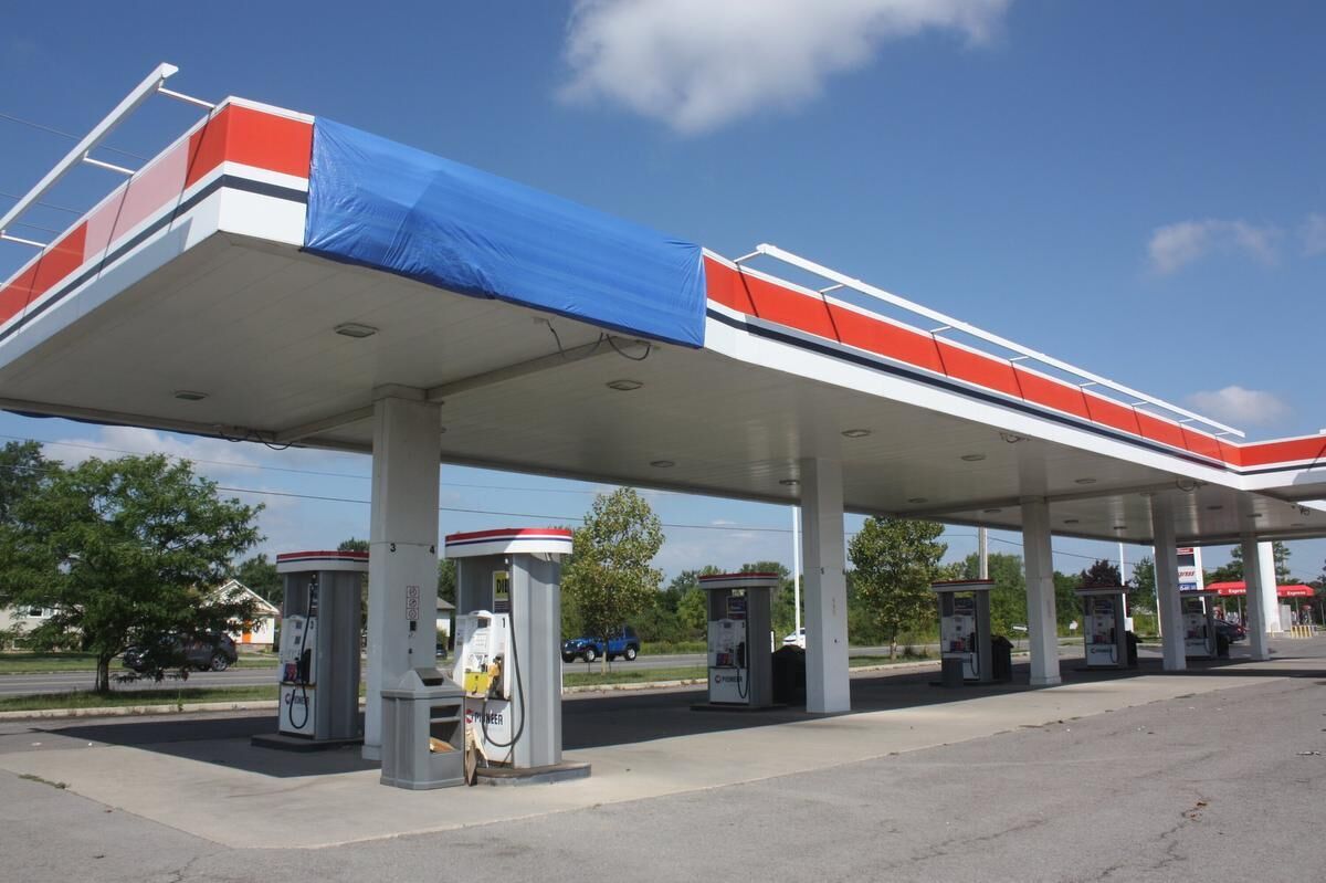 Signage at closed gas bar either removed or covered in tarps