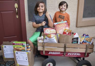 Jonah Castro, 8, and his brother Julian, 7, were inspired to raise funds and food for the Agua Fria Food Bank after seeing the homeless peddle for donations.