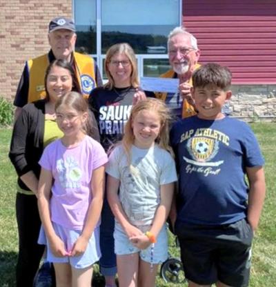 From front, left, Maisy Bayer, Emersyn Thompson, Liam Briones; middle row, Yazmin Lopez, Soar supervisor; Tower Rock principal Kelly Petrowski; back row, Sauk Prairie Lions Club president Leon Mindham on June 4.