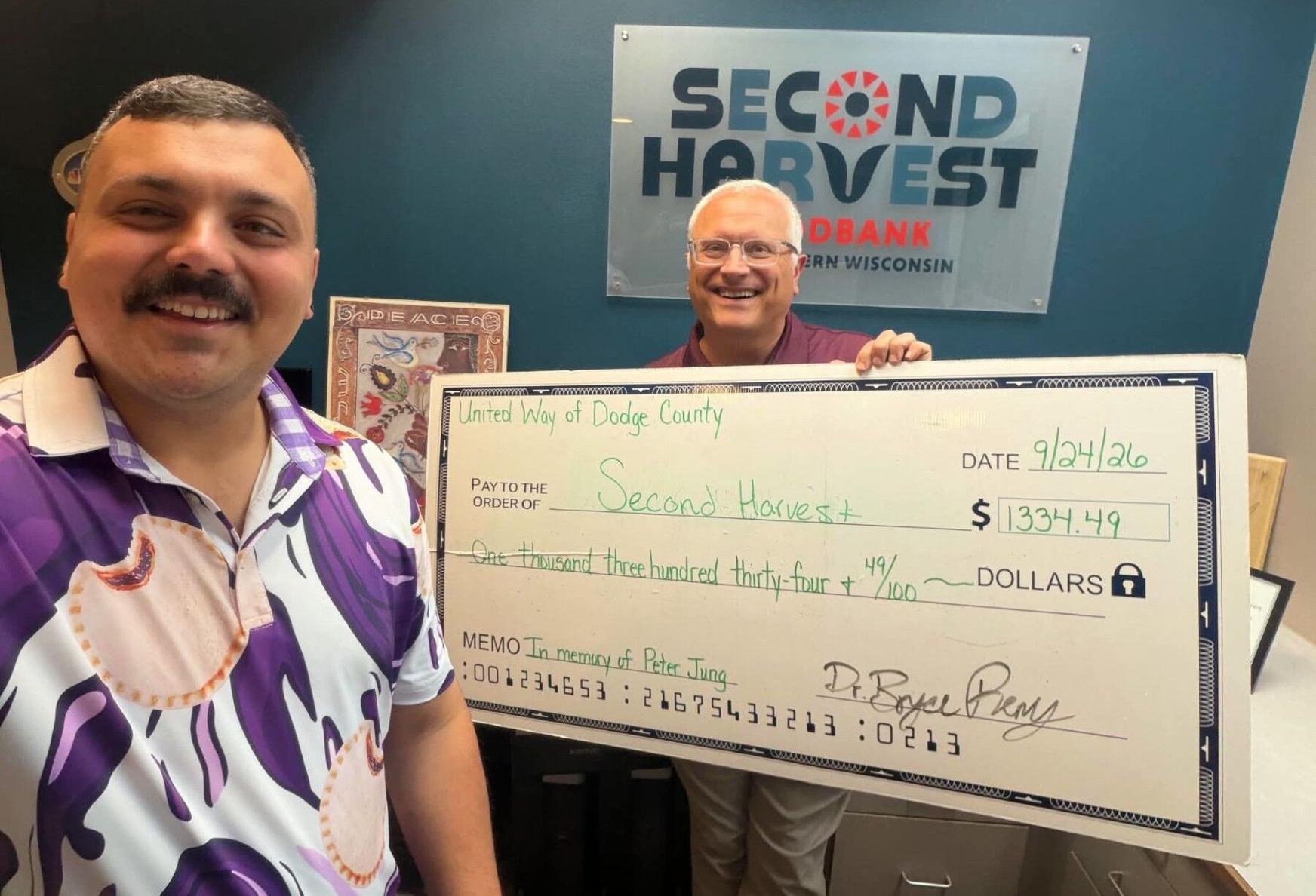 Bryce Remy, president of United Way of Dodge County, left, presents a $1,334.49 donation to Chris Ziemba, Second Harvest donor relations officer, on Sept. 24.