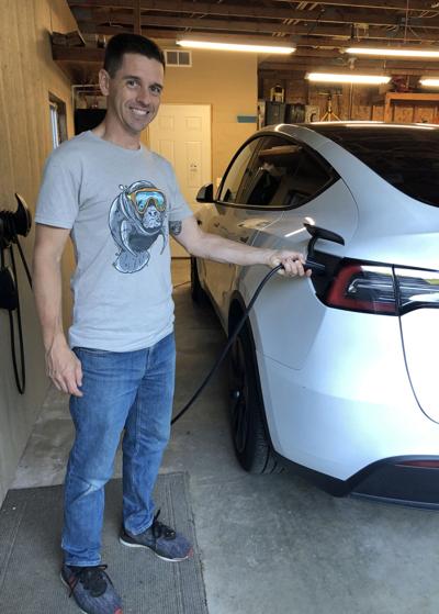 Mike Refsland, Powered Up Baraboo board member, charges his Electric Vehicle on June 22.