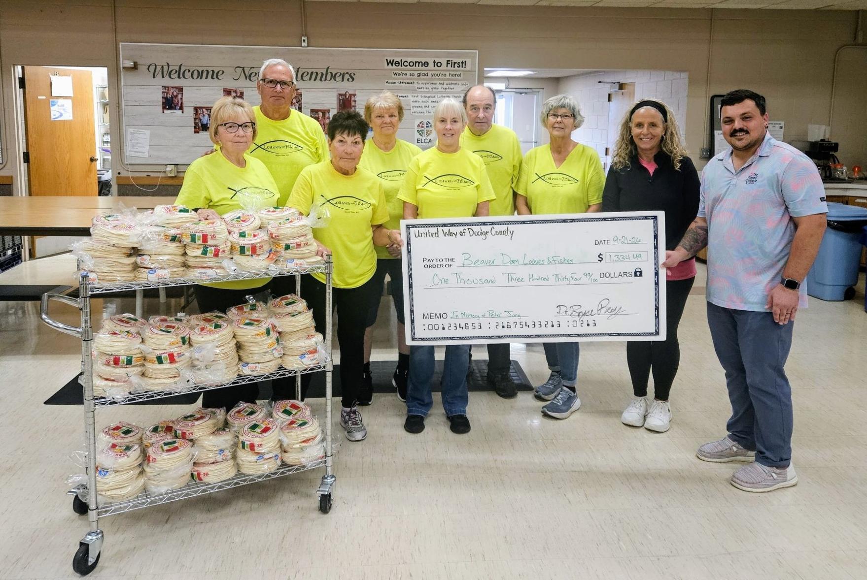 From left, Loaves and Fishes founders Linda and Jim Smedema, and pantry volunteers Diane Reul, Cindy Vogel, Laura Minnig, Jim Zuelsdorf, and Gina Toutant, accept a $1,334.49 donation from United Way of Dodge County Board Member Tammy Appel and president Bryce Remy on Sept. 21.