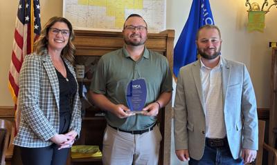Rep. Alex Dallman, center, receives a Wisconsin Counties Association Outstanding Legislator Award on July 6 from WCA Government Affairs associates Collin Driscoll, right, and Marcie Rainbolt.