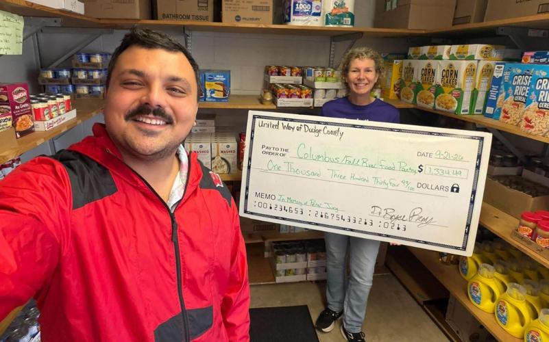 Bryce Remy, United Way of Dodge County president, left, presents Colleen Waterworth, Columbus/Fall River Food Pantry volunteer, a $1,334.49 donation on Sept. 21.