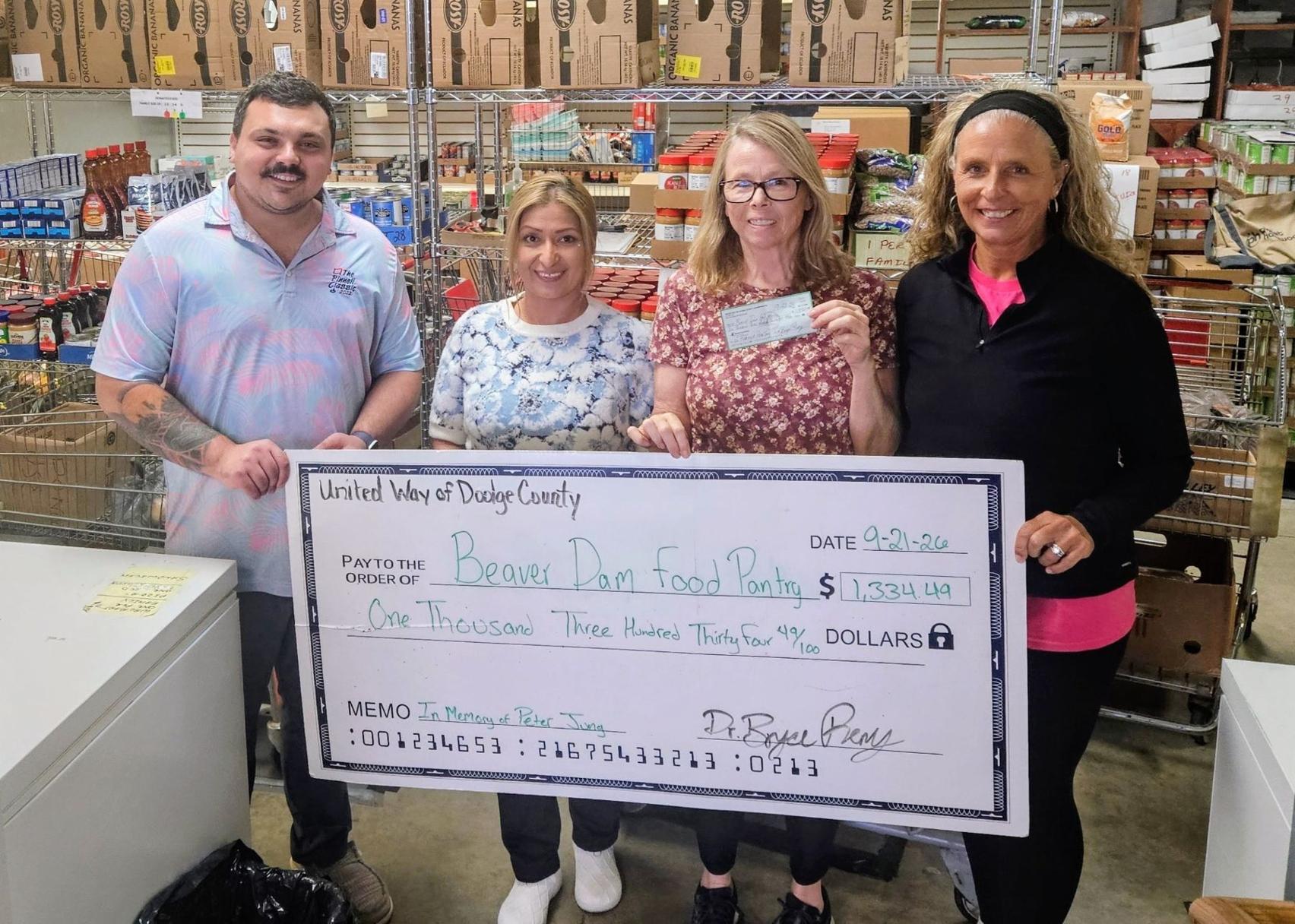 Bryce Remy, United Way of Dodge County president, left, and Tammy Appel, UWDC Board Member, right, present, from left, Corinna Jimenez, Dodge County coordinator; Pam Kuehl, Beaver Dam Food Pantry manager, a $1,334.49 donation on Sept. 21.