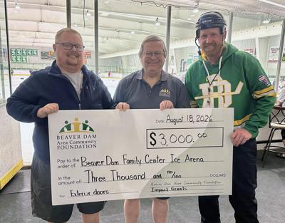 Beaver Dam Family Center Board members Ryan Owczarak, left and Jason Drake, right, accept a $3,000 grant from Beaver Dam Area Community Foundation president Tom Heffron on Aug. 18. The funds will support new exterior doors at the Beaver Dam Family Center Ice Arena.
