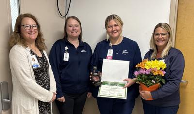 SSM Health Waupun Memorial Hospital leaders, from left, Nicole Gill, Alex Gago, and Emily Kosterman, far right, present Lauren Gallagher, an Emergency Room registered nurse, with the DAISY Award on June 19.