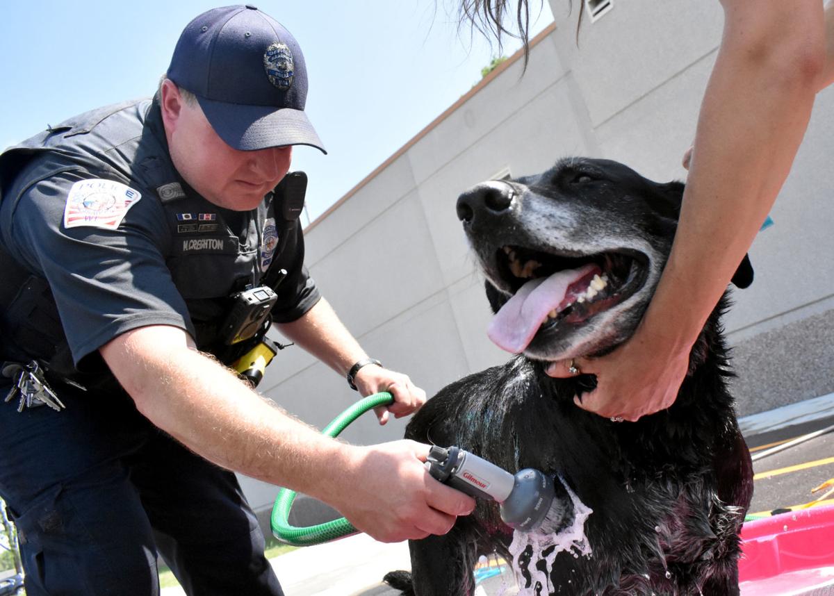 Officer Creighton washes a dog