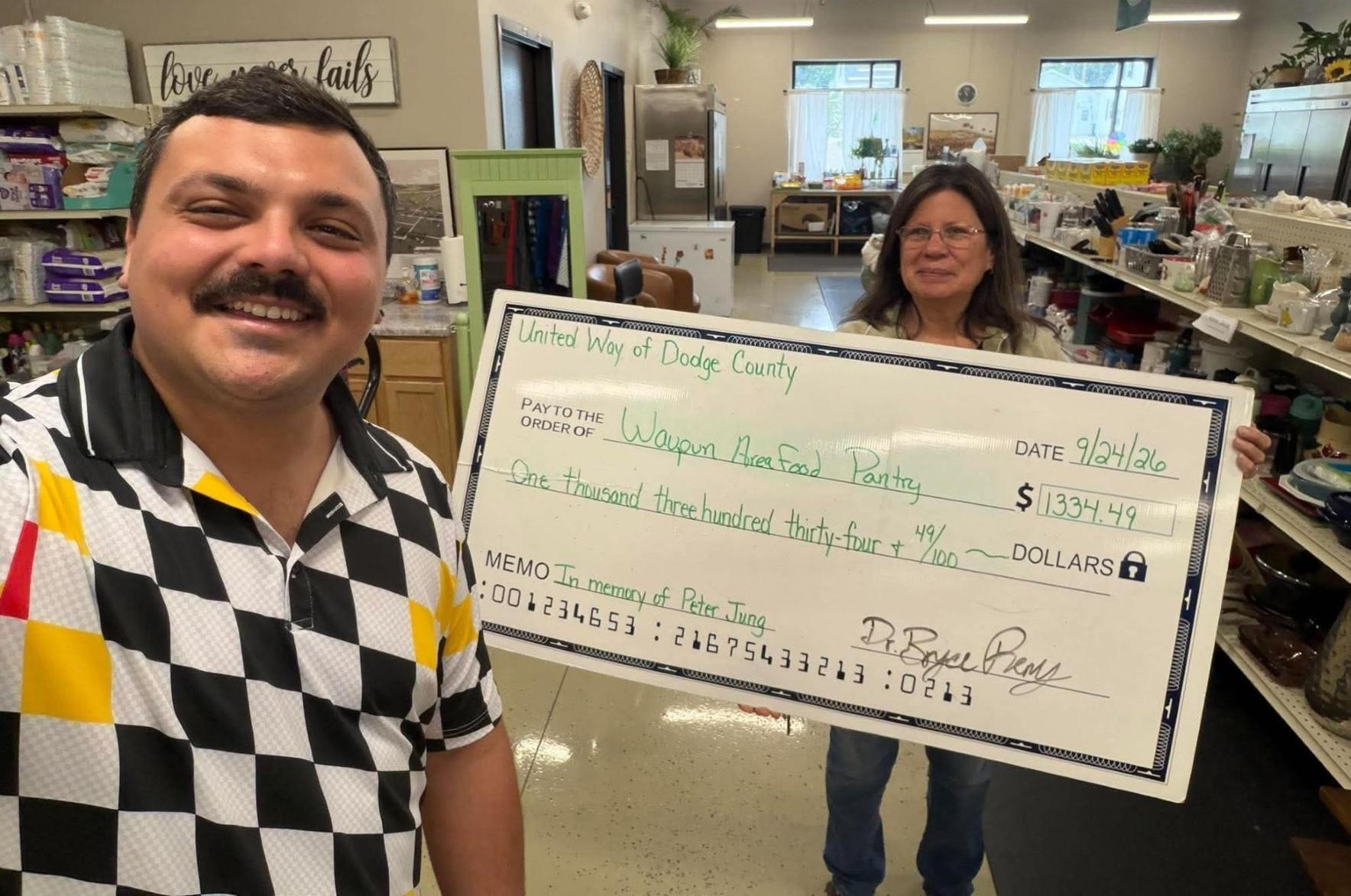 Bryce Remy, United Way of Dodge County president, left, presents a $1,334.49 donation to Terri Respalje, Waupun Area Food Pantry manager, on Sept. 24.