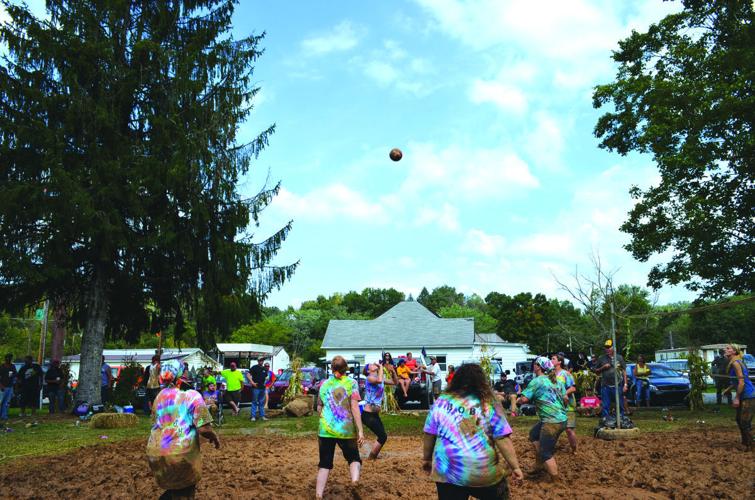 Competitors attempt to keep the ball in play during a mud volleyball tournament at the Lost Creek Community Festival Saturday.