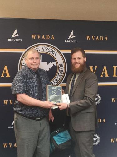 Keyser athletic director Travis Liller presents Steve Kinnie with the Distinguished Service Award from the WVADA.