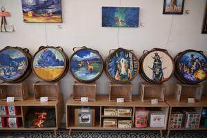 Paintings inspired by cowboy poems on barrels displayed in 'Of Here' exhibit