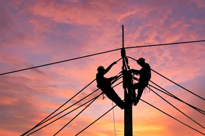 Electrician worker climbing electric power pole to repair the damaged power cable line problems after the storm. Power line support,Technology maintenance and development industry concept