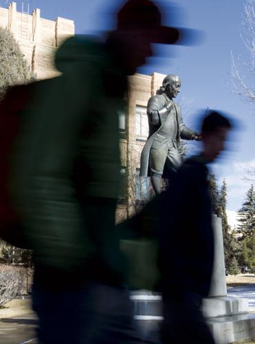 Students walking past Benjamin Franklin statue