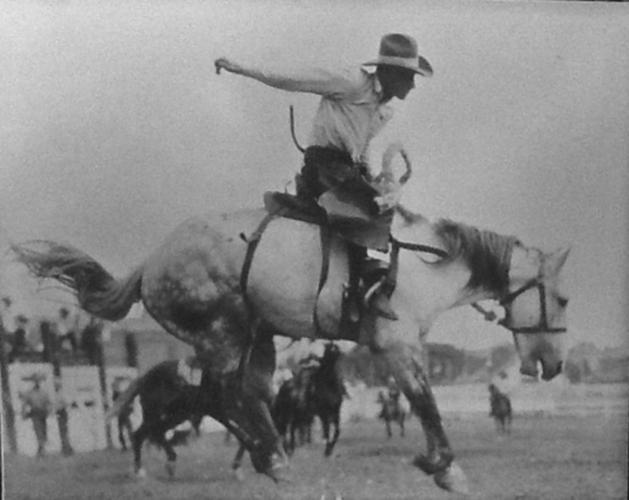 Earl Bascom riding a saddle bronc